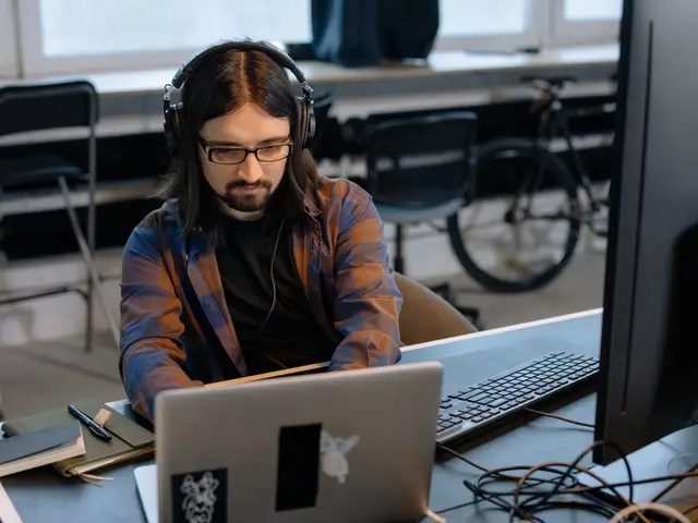 Person wearing glasses working at a computer in an office